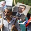 Ищет ли Россия замену Асаду? (Сириец держит плакаты с изображениями Владимира Путина и Башара Асада на акции в поддержку российски…) Сириец держит плакат…