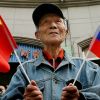США принуждают Китай к союзу с Россией (Пожилой мужчина держит китайский и российский флаги | © AFP 2019 / Mark Ralson) Пожилой мужчина держ…