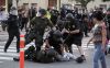 Массовые протесты в США 22-24 июля. (A protester is arrested by police officers from Orange County as protesters try to occupy the the in…) A protester is arres…